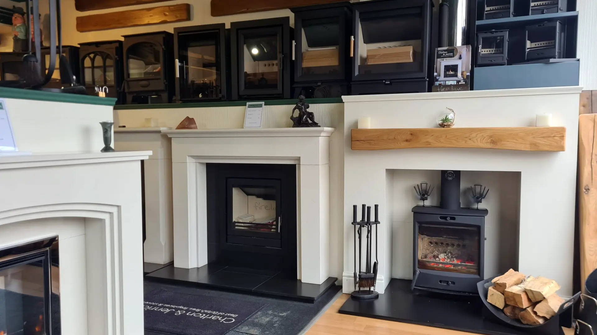 Warm Interiors showroom display of electric stoves, set into fireplace surrounds and arranged on shelves